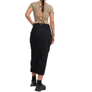 Back view of a chic long black bodycon skirt paired with a khaki tie-back crop top.