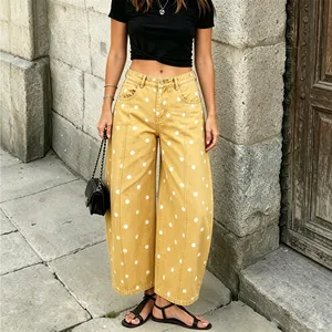 Detailed view of women's yellow mid-waist polka dot jeans in a loose wide-leg cut