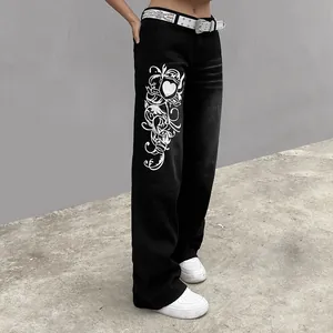 Detailed view of women's black wide-leg denim pants featuring white filigree heart graphic print