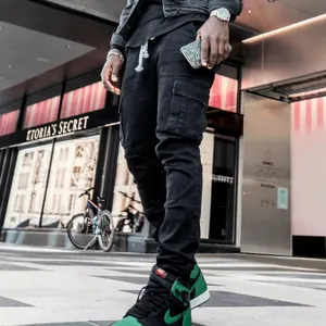 Men's slim fit black cargo jeans featuring side pockets in a stylish urban street setting