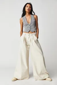 Full-length view of off-white wide-leg denim pants styled with a pinstriped vest