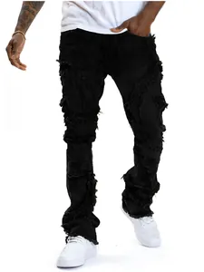 Detail view of men's black distressed flared jeans with fringe and ripped accents
