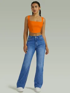 Full length view of stylish women's high waist blue stretch straight leg denim jeans.