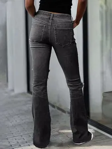 Back view of women's black washed micro-flare jeans with ripped knees and raw hem