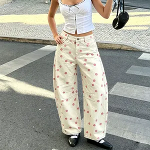 Detail view of women's low-waist polka dot curved denim pants in an urban setting