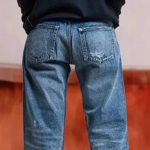 Close-up back view of women's loose straight-leg blue jeans with distressed pocket