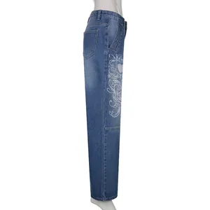 Side view of blue wide-leg jeans featuring white heart and scroll graphic prints.