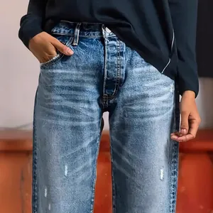 Close-up of women's loose straight-leg denim jeans with distressed light wash detail