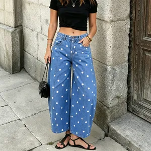 Styling detail of blue wide-leg denim pants featuring a chic white polka dot pattern design