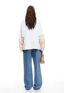 Back view of women's street style wide-leg blue denim jeans in a minimalist setting