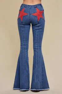 Detailed back view of blue denim flare jeans featuring bold red star patchwork