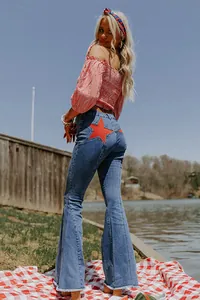 Detail view of women's flare jeans featuring a red star patch on the back pocket