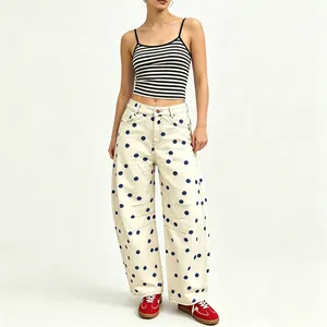 Detailed view of cream polka dot curved-leg denim pants styled with a striped top