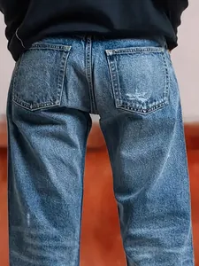 Classic women's loose fit straight-leg blue denim jeans back view with distressed pocket detail