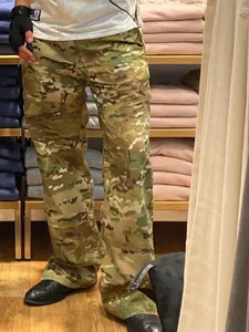 Men's loose camouflage cargo pants in tactical style shown in a retail store setting