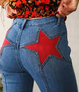 Close-up of women's blue denim jeans featuring a unique large red star patchwork design