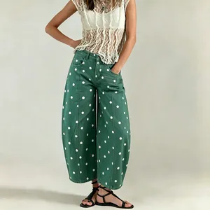 Close-up detail of green polka dot wide-leg cropped denim jeans for a stylish casual look