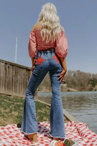 Detailed back view of high waisted blue flare jeans with bold red star patchwork