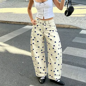 Detailed view of women's off-white polka dot denim pants with a loose barrel leg fit