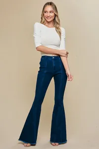 Full length view of women's high-waisted dark blue flare jeans with raw hems