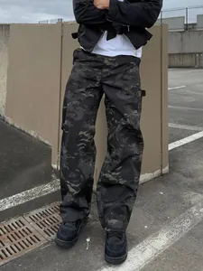 Full view of men's loose camouflage cargo pants worn in an urban street setting