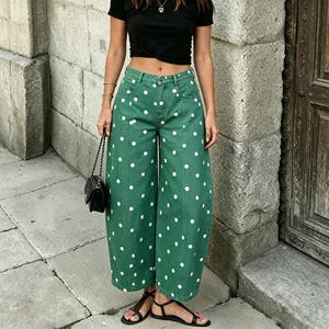 Detail of green polka dot denim pants with stylish relaxed curved leg design in street style