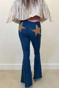 Back view of stylish blue flare jeans for women featuring unique brown suede star patches