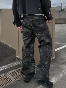 Close-up rear view of men's loose dark camouflage cargo pants in urban setting