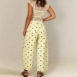 Back view of women's mid-waist polka dot wide-leg cropped denim jeans in pale yellow