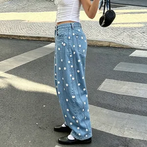 Detailed view of women's loose curved denim pants with white polka dot patterns