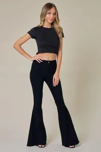 Full-body studio view showing the fit and flared leg of black high-waisted jeans