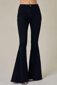 Close-up of black high-waisted flared jeans with front seams and frayed hem