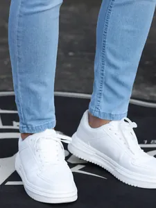 Vista dettagliata dell'orlo alla caviglia di jeans skinny elasticizzati da uomo blu chiaro.