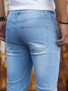 Dettaglio ravvicinato della tasca posteriore di jeans denim stretch azzurri da uomo.