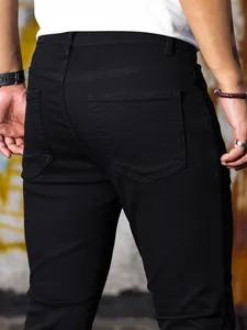 Dettaglio tasche posteriori su jeans in denim elasticizzato nero slim fit da uomo