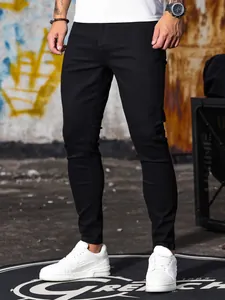 Jeans skinny neri elasticizzati da uomo abbinati a sneakers bianche in stile urbano.