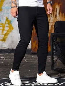 Vista dettagliata di jeans neri elasticizzati slim fit da uomo in un contesto urbano