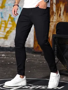 Dettaglio dei jeans neri elasticizzati da uomo abbinati a sneakers bianche alla moda.