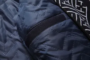 Vista detallada del forro acolchado azul marino y el cuello con patrón de un abrigo de lana