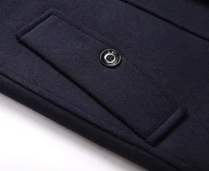 Detalle macro del bolsillo de un abrigo de lana azul marino con botón y textura fina.