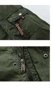 Macro view of green men's jacket showing high-quality zipper and pocket detail