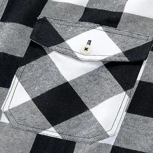Detailansicht einer schwarz-weißen Holzfällerhemd-Tasche mit edlem Knopf-Detail.