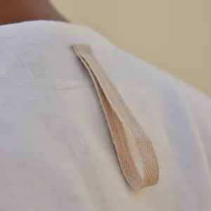 Detailed macro shot of the hanging loop on a white cotton linen long robe for men