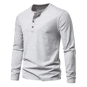 Close-up detail of a casual men's gray long-sleeved Henley shirt with four brown buttons