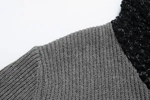 Macro view of the ribbed knit texture and patchwork shoulder seam on a men's sweater