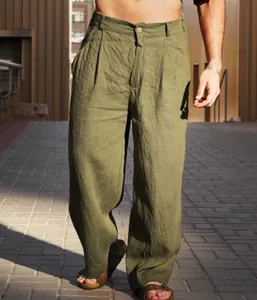Detail shot of men's olive green linen pleated trousers in casual outdoor setting.