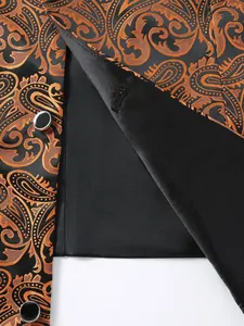Close-up of black and orange paisley jacquard fabric and lining on a men's suit vest.