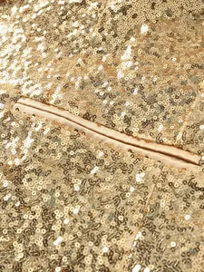 Detailed macro view showing the glittering gold sequins and pocket on a stage suit