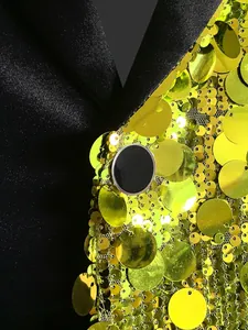 Dettaglio ravvicinato di paillettes verde lime e revers in raso nero su blazer da festa