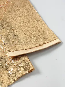 Detail of shiny gold sequined suit jacket sleeve with satin trim for stage performance